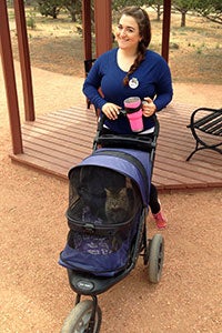 Volunteer Ines Lopes pushing a kitty stroller