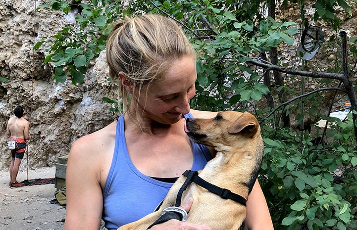 Kim holding Harwood the dog while out on a hike