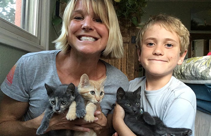 Jill and one of her sons holding three foster kittens
