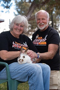 Bunny House volunteers Barbara and Larry holding Cinnabun the rabbit