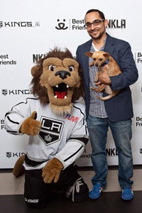 Man holding the Chihuahua he adopted at the Los Angeles Kings game