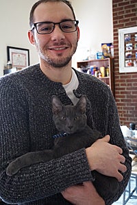 Earl the Siamese and Russian blue mix cat with his adopter