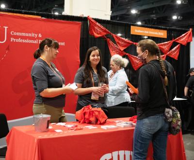 Representative from Southern Utah University talking with a Best Friends Conference attendee