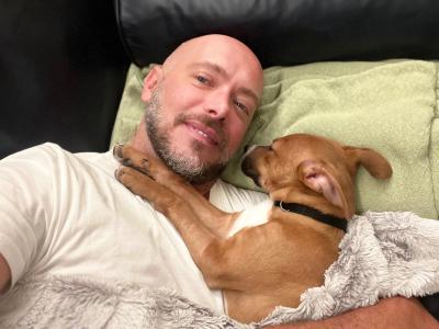 Donna the dog snuggling in bed with her adopter