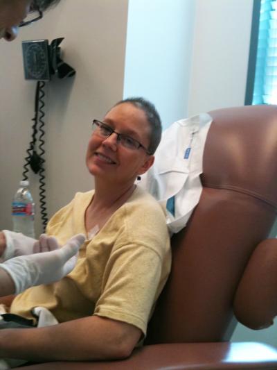 Best Friends CEO Julie Castle sitting in a big chair undergoing chemo treatment