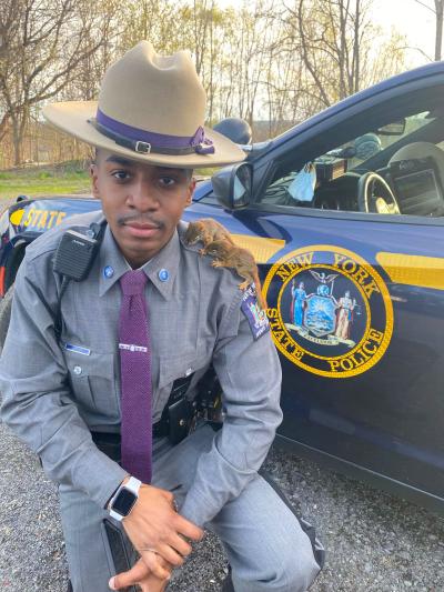 New York state trooper LaVonte Lee with two baby squirrels on his shoulder