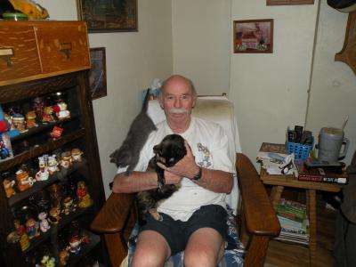 Volunteer Steve Pack holding a cat and a kitten in his house