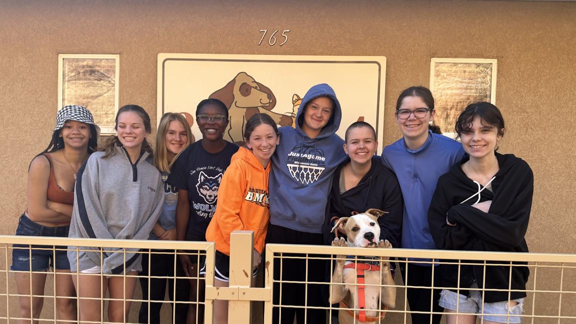 Girl Scout Troop 1019 together at Best Friends Animal Sanctuary with a dog