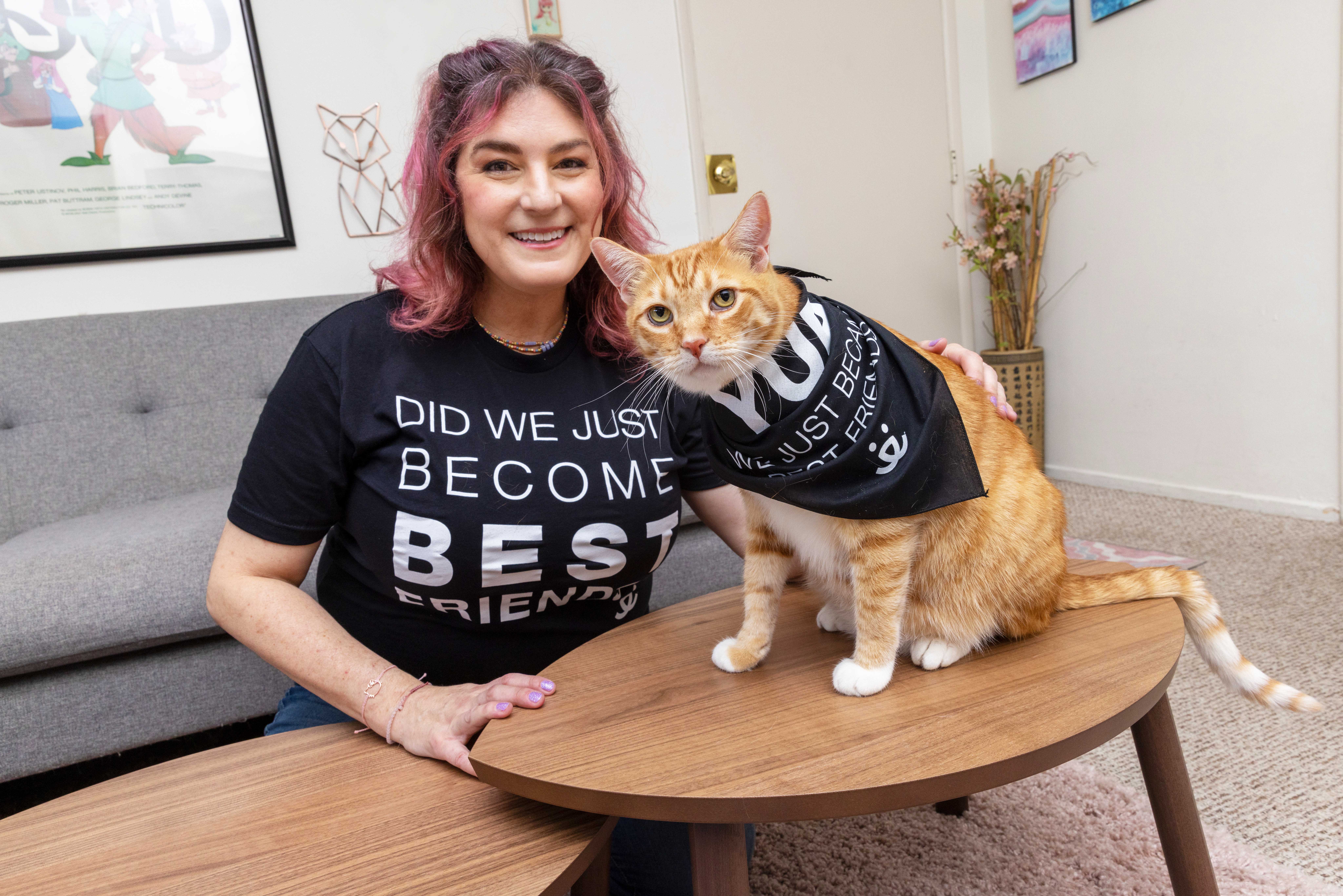 Smiling person wearing a Best Friends T-shirt that coincides with a bandanna a cat is wearing