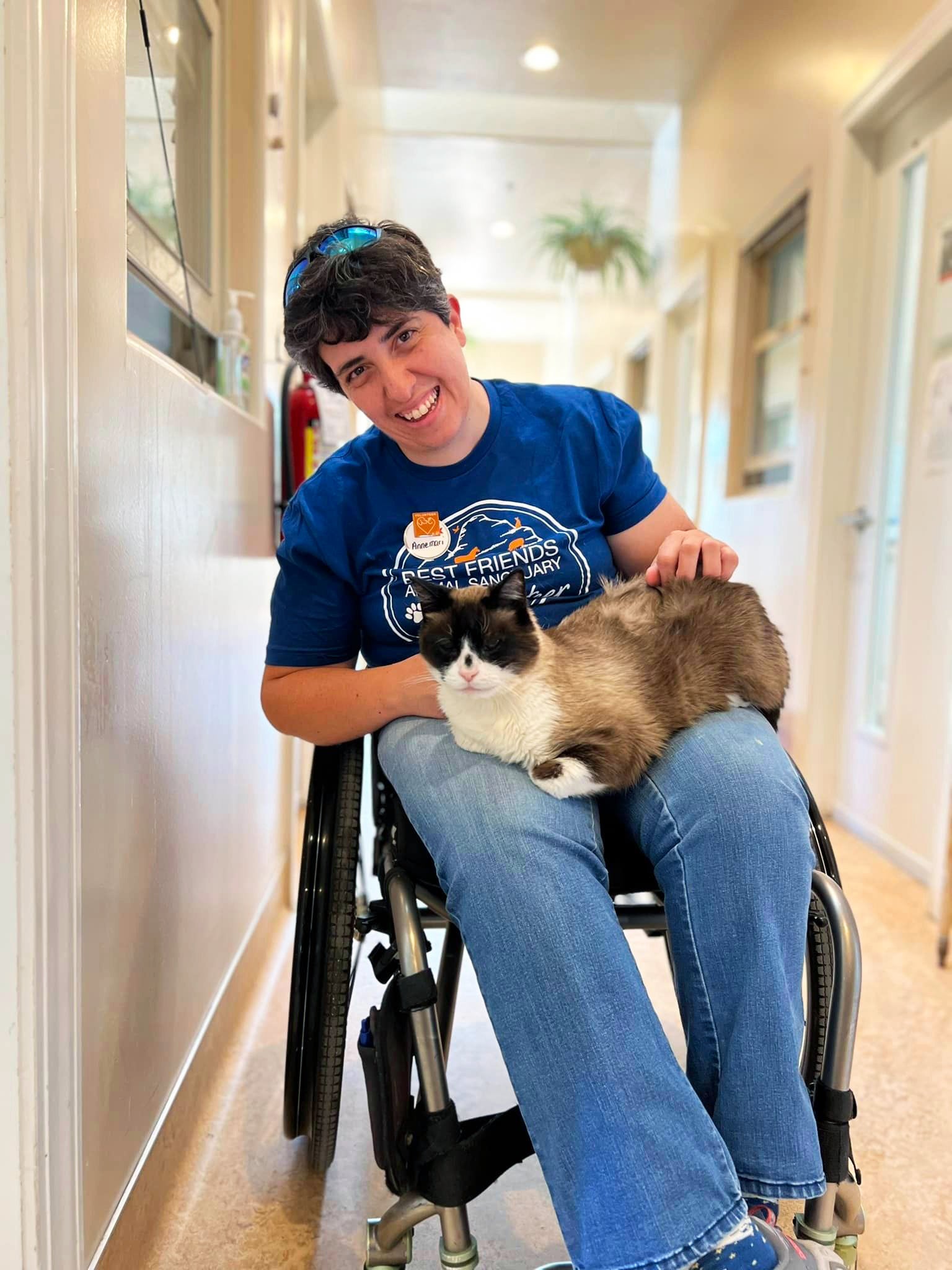 Best Friends volunteer in a wheelchair with a cat in her lap