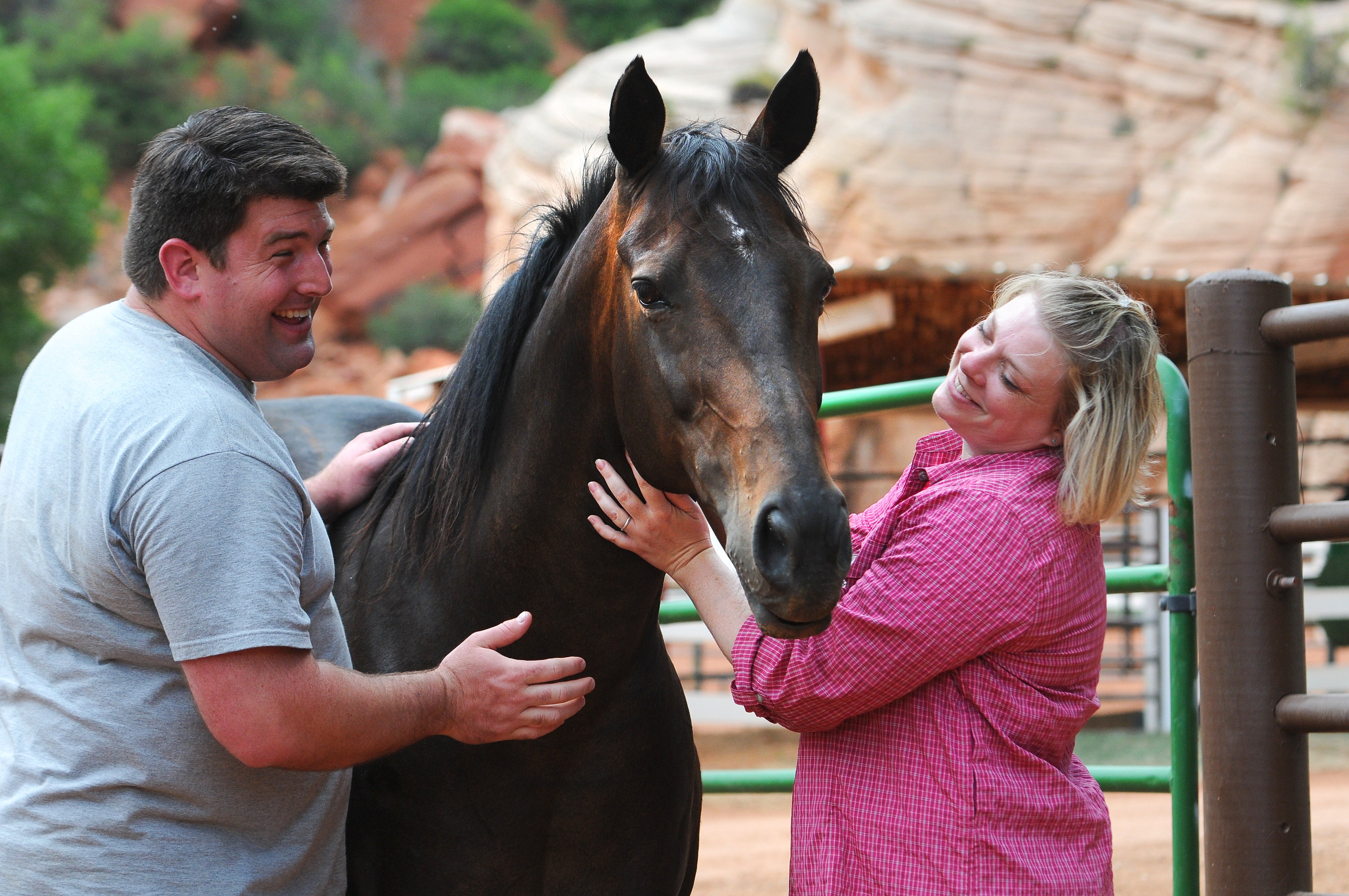 Two smiling people standing outside with a horse at Best Friends Animal Sanctuary