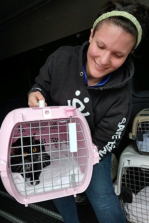 Emily Smith holding a pet carrier containing a cat