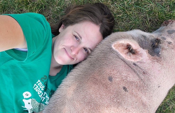 Jennifer West lying next to Diesel the pig
