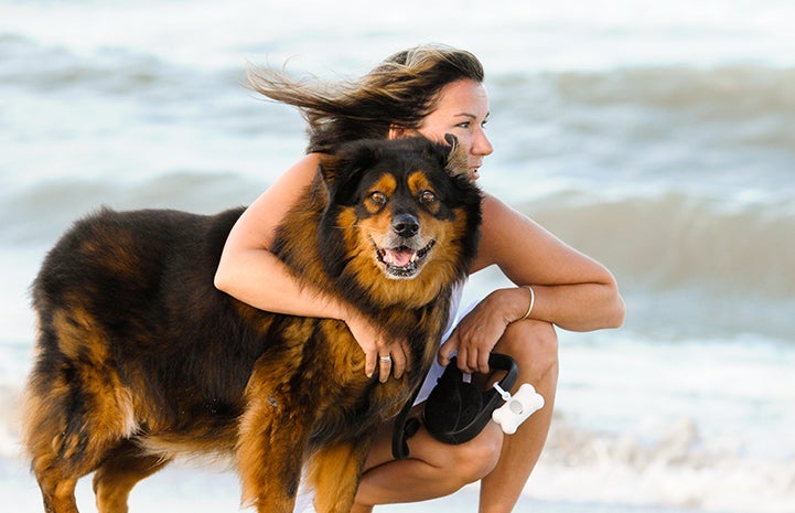Vicki Kilmer, director of business intelligence and strategy, with Kiri the dog with the ocean behind them