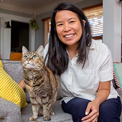 Angela Li sitting on a couch with a cat