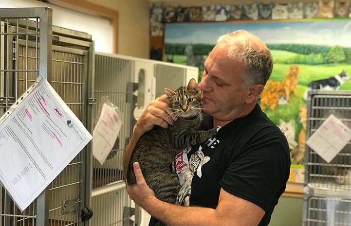Tom Hubric holding Ariel the brown tabby cat