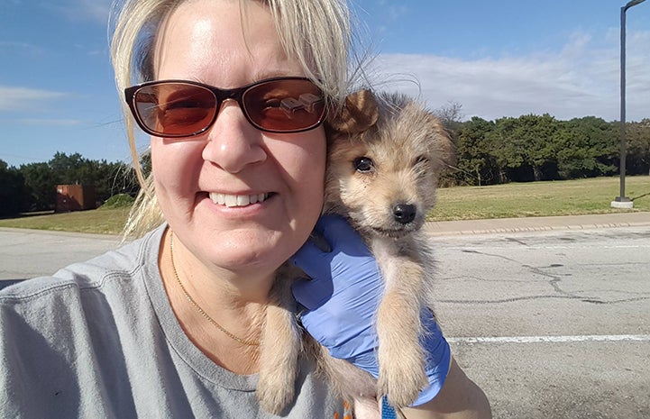 Sherri Bock Slattery volunteering to transport puppies and holding a puppy during a rest stop