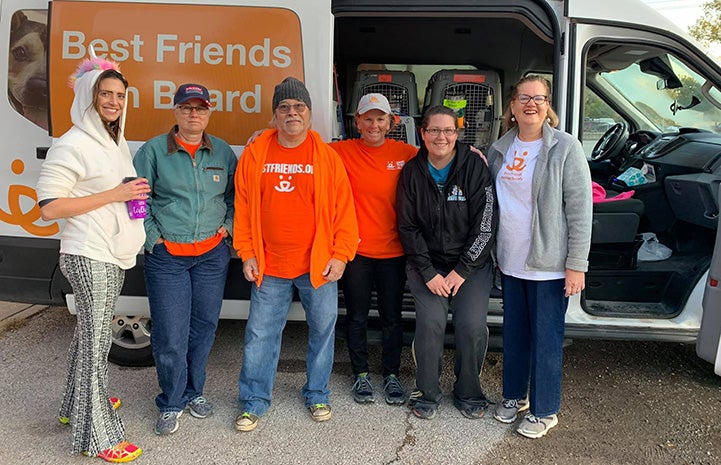 Group of people standing in front of a Best Friends transport van