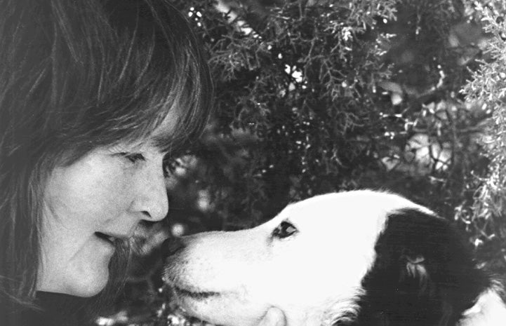 Black and white photo of Faith Maloney face-to-face with Tammy the dog