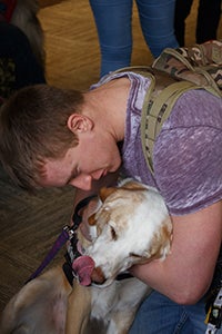 Young man hugging Faith the therapy dog