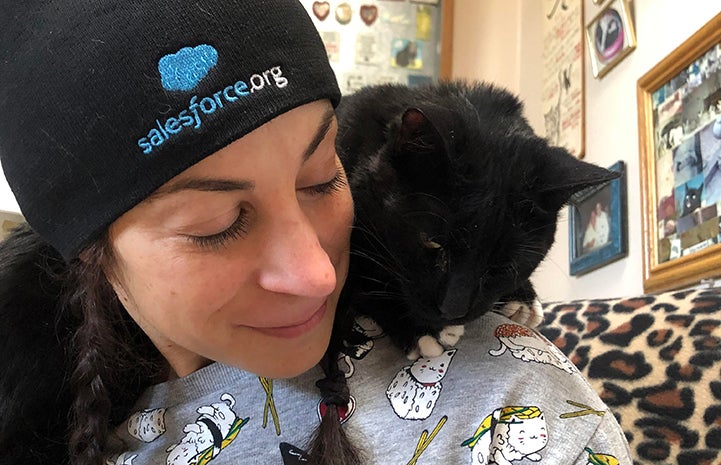 Natalie volunteering at Cat World with a black cat on her shoulder