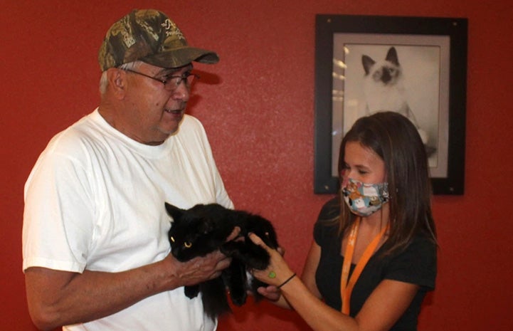 Woman handing Miss Corona the cat to David