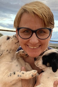 Christina Pham Linhoff holding two puppies