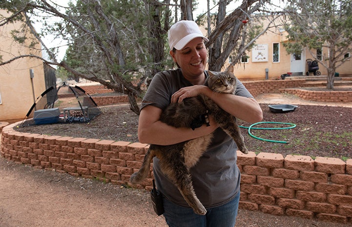 A woman carrying Maxine the cat outside