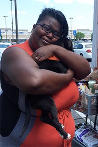 Carra hugging and holding Cocoa Puff, the puppy her husband just adopted for her