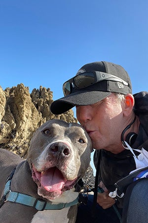 Danny kissing Cannoli the dog's head during a trip out to the coast