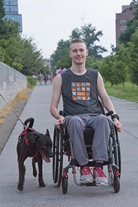 Bagel the dog sitting next to Cougar Clifford in his wheelchair