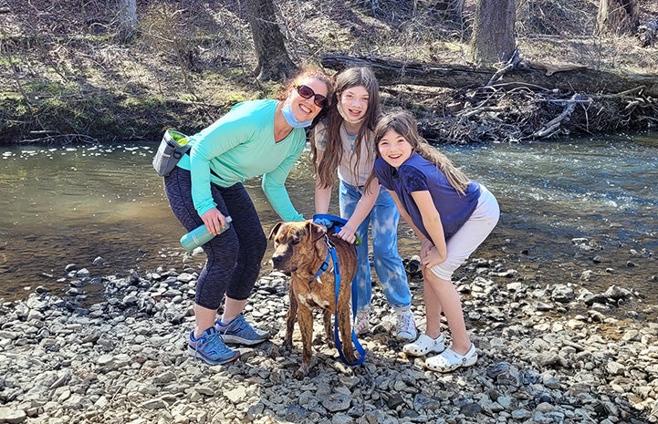 The family with Pancho the dog, next to a stream