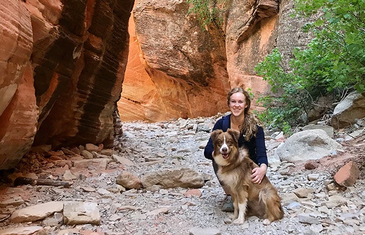 Woman and Scout the dog in a slot canyon