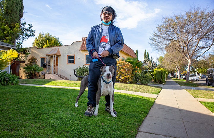 Man walking Neville the dog outside on a leash