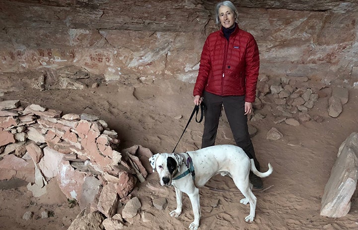 Volunteer Heather Harding with Peter the dog hiking in a cave area