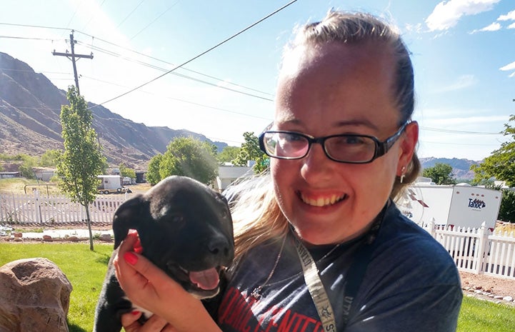 Smiling woman holding one of Frannie the dog's puppies