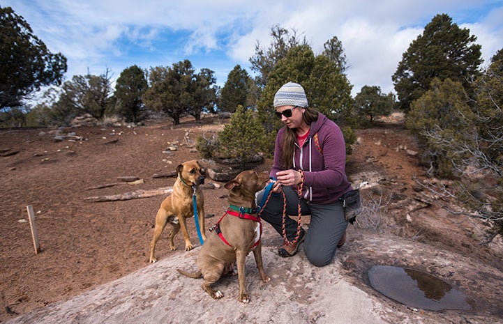 Dogtown caregiver Jess Cieplinski taking a hike with dogs Cosette and Cleveland