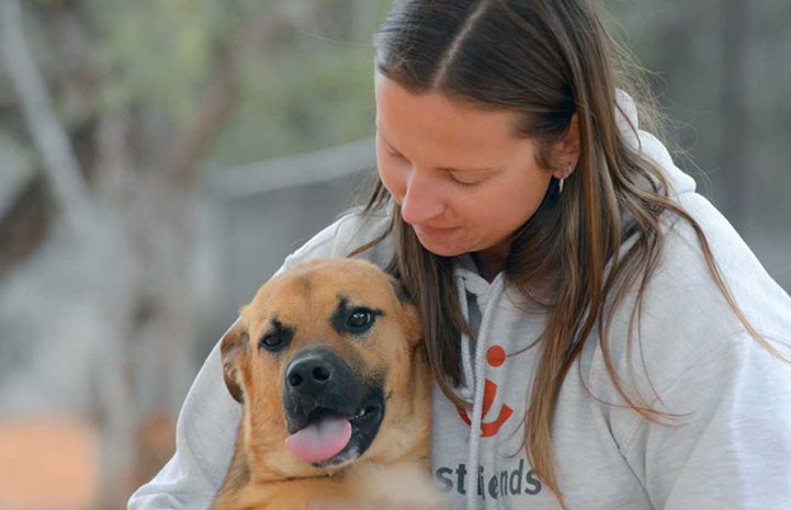 Dogtown caregiver Jess Cieplinski hugging Klaus the dog