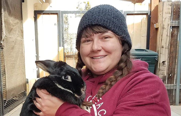 Biff the rabbit being held by caregiver Keala