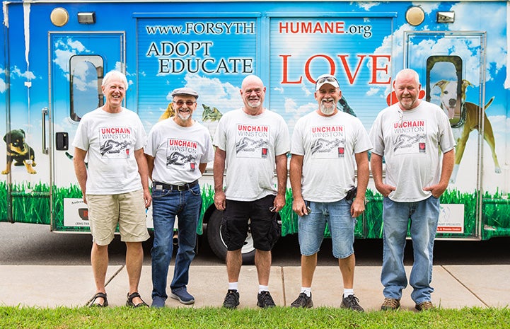People standing in front of a mobile adoption vehicle