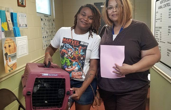 Two smiling women with a cat in a carrier