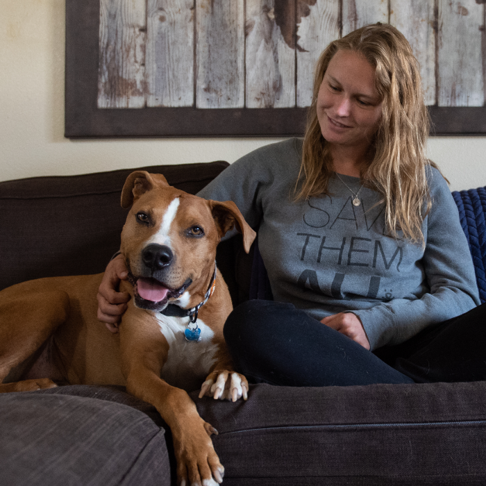 Young girl with foster dog sitting on the couch