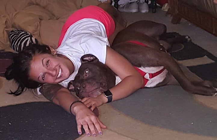 Bonnie, lying on the floor and hugging Bonnie the dog