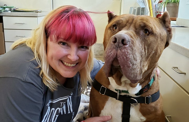 Woman with blond and pink hair posing with Ludo the dog