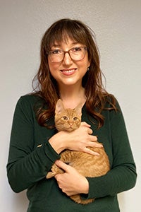 Sarah, Hock, executive director of Joint Animal Services in Washington, holding an orange tabby cat