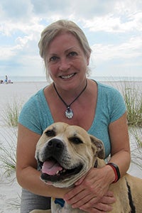 Kathy Stolzenburg with a dog on a beach