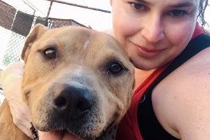 A selfie taken by Tessa of her with Seymour, a brown and white pit bull terrier type dog