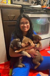 Sonali Mitra holding three puppies