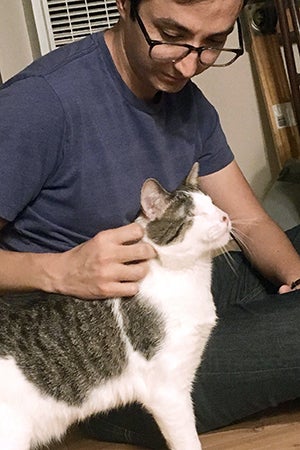 Melvin the blind cat being petted by his adopter, Ellison