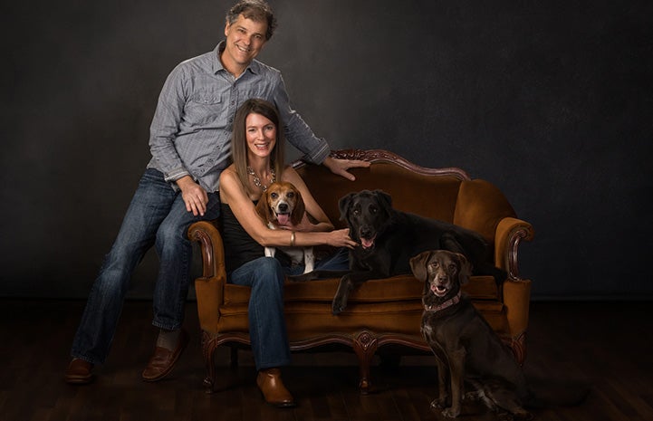 Formal family portrait of Rick Jones and Donna Hampton with Larry the dog along with two other dogs